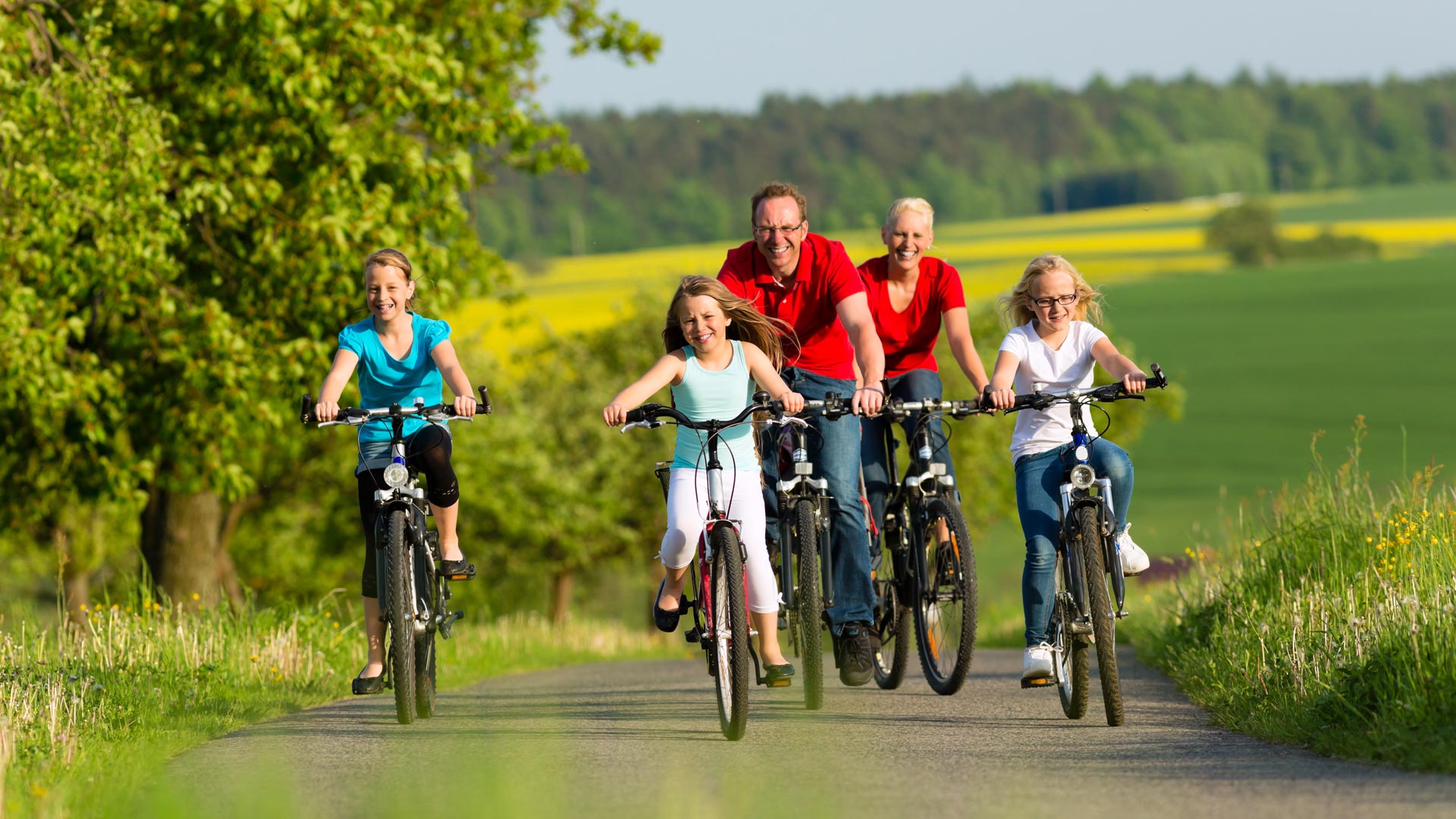 Family with kids cycling in summer with bicycles